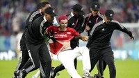 Pihak keamanan berhasil menggiring seorang suporter itu keluar lapangan. (Foto: AP/Martin Meissner)