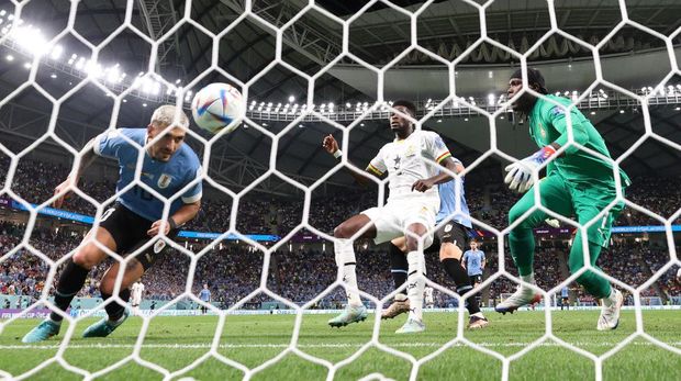 AL WAKRAH, QATAR - DECEMBER 02: (EDITORS NOTE: In this photo taken from a remote camera from behind the goal) Giorgian de Arrascaeta of Uruguay scores the team's first goal during the FIFA World Cup Qatar 2022 Group H match between Ghana and Uruguay at Al Janoub Stadium on December 02, 2022 in Al Wakrah, Qatar. (Photo by Elsa/Getty Images)