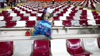 Mereka menyelusuri seluruh tribun sambil membawa plastik sampah.