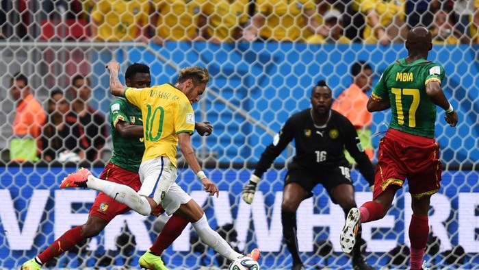 Neymar of Brazil (2-L) takes a shot against Cameroons Nicolas Nkoulou (L) and goal keeper Charles Itandje (2-R) during the FIFA World Cup 2014 group A preliminary round match between Cameroon and Brazil at the Estadio Nacional in Brasilia, Brazil, 23 June 2014. Photo: Marius Becker/dpa (RESTRICTIONS APPLY: Editorial Use Only, not used in association with any commercial entity - Images must not be used in any form of alert service or push service of any kind including via mobile alert services, downloads to mobile devices or MMS messaging - Images must appear as still images and must not emulate match action video footage - No alteration is made to, and no text or image is superimposed over, any published image which: (a) intentionally obscures or removes a sponsor identification image; or (b) adds or overlays the commercial identification of any third party which is not officially associated with the FIFA World Cup) EDITORIAL USE ONLY | usage worldwide   (Photo by Marius Becker/picture alliance via Getty Images)