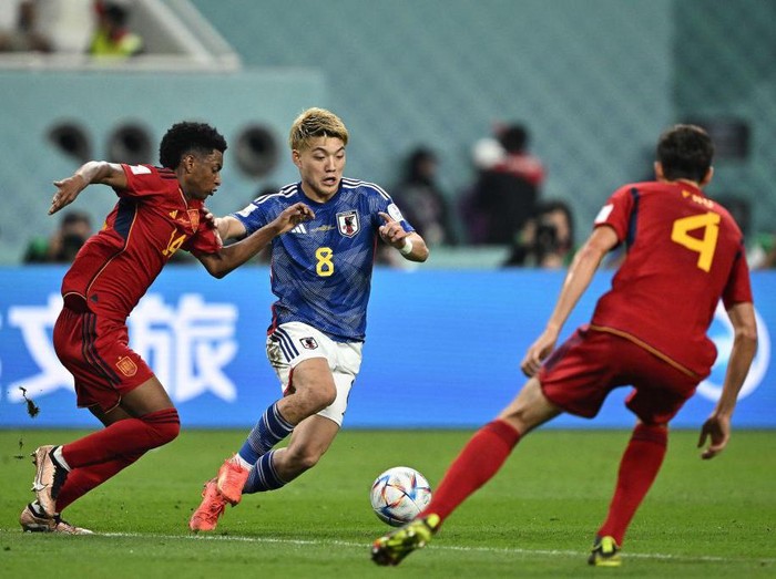 Japan's midfielder #08 Ritsu Doan (C) fights for the ball with Japan's midfielder #14 Junya Ito (L) and Spain's defender #04 Pau Torres during the Qatar 2022 World Cup Group E football match between Japan and Spain at the Khalifa International Stadium in Doha on December 1, 2022. (Photo by Philip FONG / AFP) (Photo by PHILIP FONG/AFP via Getty Images)
