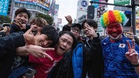 Suporter Jepang merayakan kegembiraan di persimpangan Shibuya, Tokyo usai menumbangkan Spanyol 2-1 pada Kamis (1/12/2022).   
