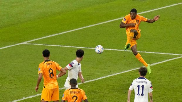 Denzel Dumfries of the Netherlands, right, scores his side's third goal during the World Cup round of 16 soccer match between the Netherlands and the United States, at the Khalifa International Stadium in Doha, Qatar, Saturday, Dec. 3, 2022. (AP Photo/Luca Bruno)