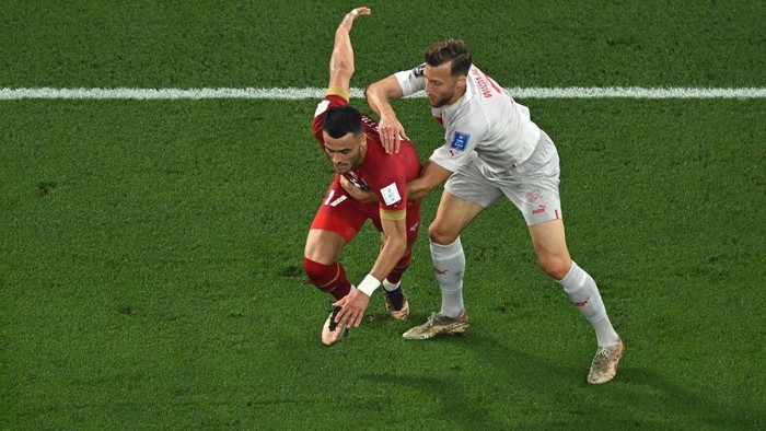 Switzerlands defender #03 Silvan Widmer grabs Serbias midfielder #17 Filip Kostic during the Qatar 2022 World Cup Group G football match between Serbia and Switzerland at Stadium 974 in Doha on December 2, 2022. (Photo by MANAN VATSYAYANA / AFP) (Photo by MANAN VATSYAYANA/AFP via Getty Images)