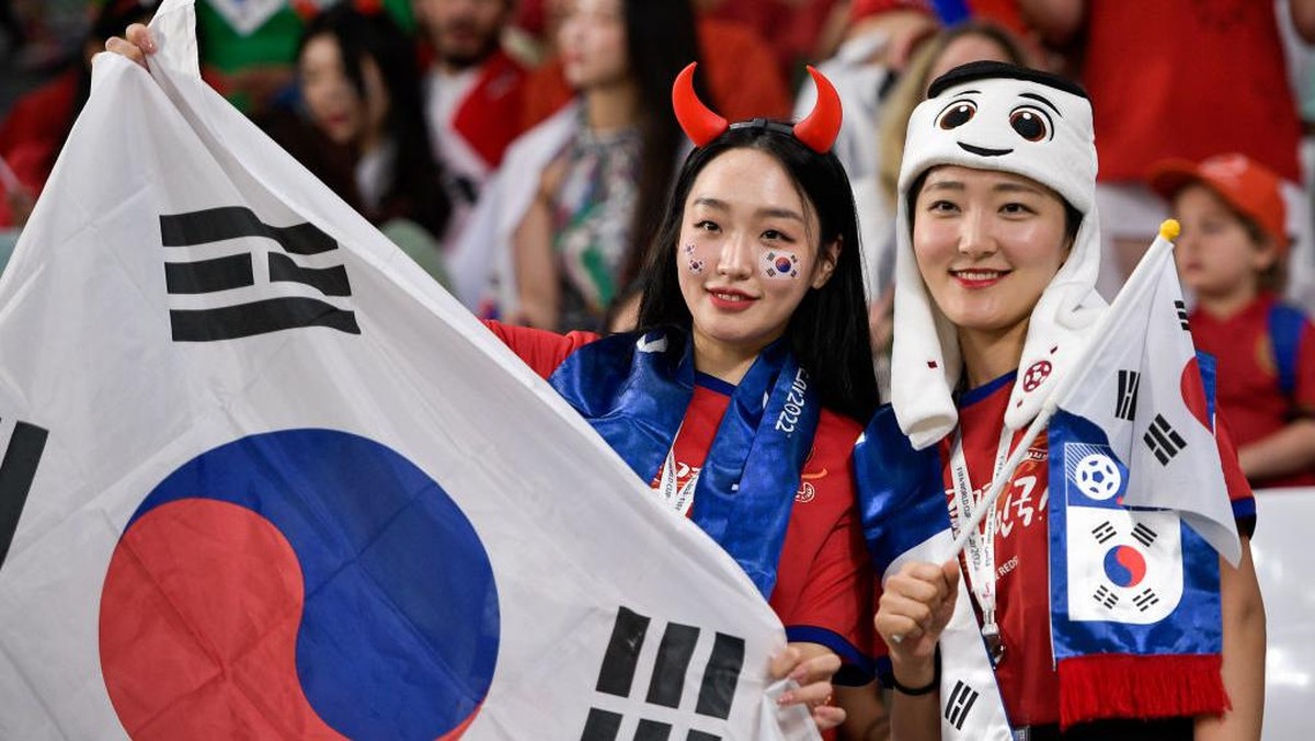 Suporter Korea Selatan hadir memberikan dukungan langsung di laga melawan Portugal. Foto: Getty Images/BSR Agency