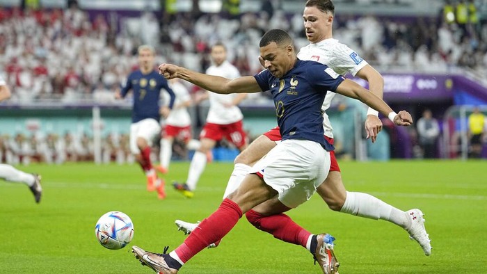 Frances Kylian Mbappe, left, and Polands Matty Cash vie for the ball during the World Cup round of 16 soccer match between France and Poland, at the Al Thumama Stadium in Doha, Qatar, Sunday, Dec. 4, 2022. (AP Photo/Ebrahim Noroozi)