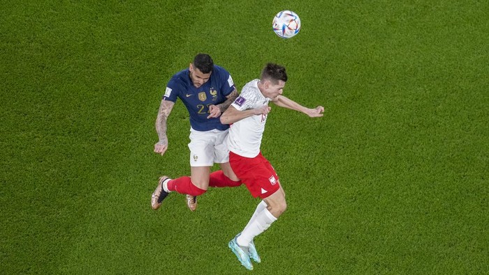 Frances Theo Hernandez, left, fights for the ball with Polands Jakub Kaminski during the World Cup round of 16 soccer match between France and Poland, at the Al Thumama Stadium in Doha, Qatar, Sunday, Dec. 4, 2022. (AP Photo/Thanassis Stavrakis)