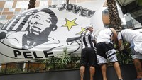 Pendukung tim sepak bola Santos memasang spanduk bergambar mantan bintang sepakbola Pele di depan rumah sakit Albert Einstein di Sao Paulo, Brasil, Minggu (4/11/2022).  
