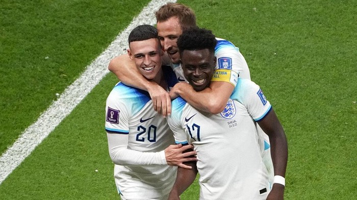 Englands Bukayo Saka, right, celebrates with Englands Phil Foden, left, and Englands Harry Kane after scoring his sides 3rd goal during the World Cup round of 16 soccer match between England and Senegal, at the Al Bayt Stadium in Al Khor, Qatar, Sunday, Dec. 4, 2022. (AP Photo/Ariel Schalit)