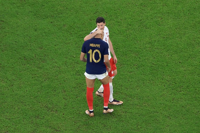 Kylian Mbappe dan Robert Lewandowski DOHA, QATAR - DECEMBER 04: Robert Lewandowski of Poland embraces Kylian Mbappe of France after the FIFA World Cup Qatar 2022 Round of 16 match between France and Poland at Al Thumama Stadium on December 04, 2022 in Doha, Qatar. (Photo by Buda Mendes/Getty Images)