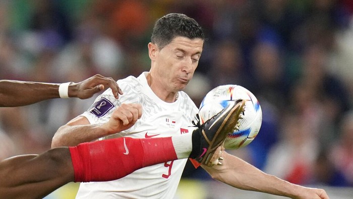 France's Aurelien Tchouameni, left, fights for the ball with Poland's Robert Lewandowski during the World Cup round of 16 soccer match between France and Poland, at the Al Thumama Stadium in Doha, Qatar, Sunday, Dec. 4, 2022. (AP Photo/Moises Castillo)