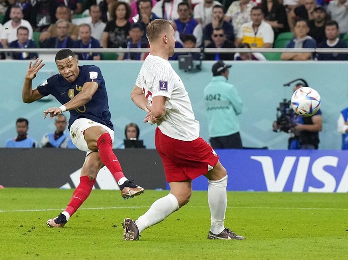 France's Kylian Mbappe, left, scores his side's second goal during the World Cup round of 16 soccer match between France and Poland, at the Al Thumama Stadium in Doha, Qatar, Sunday, Dec. 4, 2022. (AP Photo/Ricardo Mazalan)