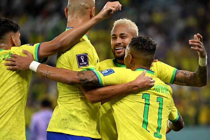 Brazil's forward #10 Neymar celebrates with teammates after scoring his team's second goal from the penalty spot during the Qatar 2022 World Cup round of 16 football match between Brazil and South Korea at Stadium 974 in Doha on December 5, 2022. (Photo by Pablo PORCIUNCULA / AFP) (Photo by PABLO PORCIUNCULA/AFP via Getty Images)