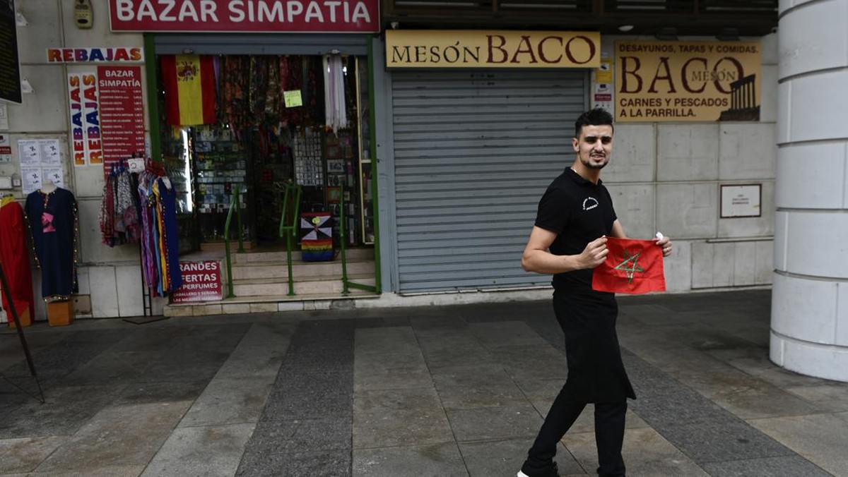 Seorang pria di Ceuta membentangkan bendera Maroko. Foto: AP/Antonio Sempere