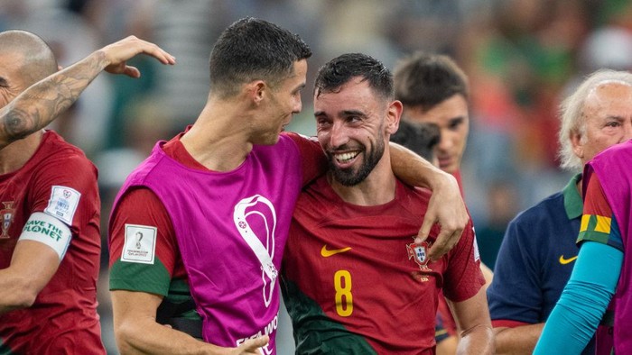 LUSAIL, QATAR - NOVEMBER 28: Cristiano Ronaldo #7 of Portugal celebrates with Bruno Fernandes #8 after a FIFA World Cup Qatar 2022 Group H match between Uruguay and Portugal at Lusail Stadium on November 28, 2022 in Lusail, Qatar. (Photo by John Todd/ISI Photos/Getty Images)