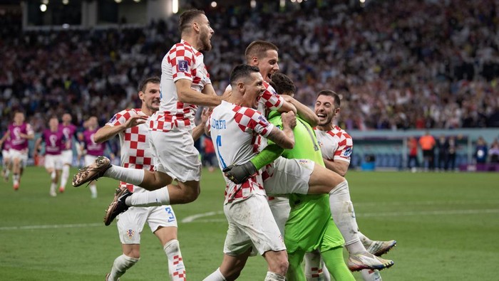 AL WAKRAH, QATAR - DECEMBER 05: Croatia players celebrate with goalkeeper Dominik Livakovic after he saves three penalties in the shoot out during the FIFA World Cup Qatar 2022 Round of 16 match between Japan and Croatia at Al Janoub Stadium on December 5, 2022 in Al Wakrah, Qatar. (Photo by Visionhaus/Getty Images)
