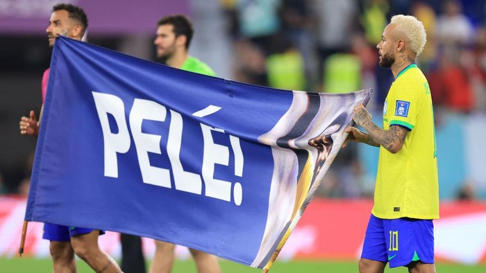 DOHA, QATAR - DECEMBER 05: Neymar of Brazil holds a banner showing support for former Brazil player Pele after the FIFA World Cup Qatar 2022 Round of 16 match between Brazil and South Korea at Stadium 974 on December 05, 2022 in Doha, Qatar. (Photo by Buda Mendes/Getty Images)