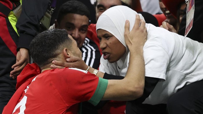 AL RAYYAN, QATAR - DECEMBER 06: Achraf Hakimi of Morocco is seen with a fan at full time during the FIFA World Cup Qatar 2022 Round of 16 match between Morocco and Spain at Education City Stadium on December 06, 2022 in Al Rayyan, Qatar. (Photo by Ian MacNicol/Getty Images)