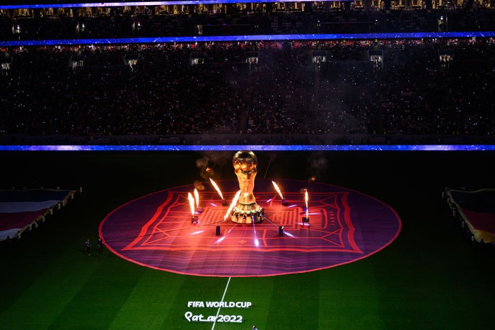 Logo Piala Dunia 2022 AL KHOR, QATAR - DECEMBER 01: General view of the pre match ceremony with the flags and a copy of the trophy of the World Cup with firework prior to the FIFA World Cup Qatar 2022 Group E match between Costa Rica and Germany at Al Bayt Stadium on December 01, 2022 in Al Khor, Qatar. (Photo by Markus Gilliar - GES Sportfoto/Getty Images)