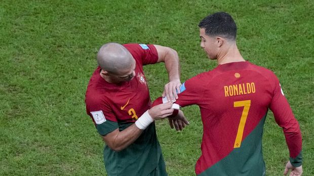 Portugal's Pepe places the captain armband on the arm of teammate Cristiano Ronaldo as he replaces him during the World Cup round of 16 soccer match between Portugal and Switzerland, at the Lusail Stadium in Lusail, Qatar, Tuesday, Dec. 6, 2022. (AP Photo/Frank Augstein)