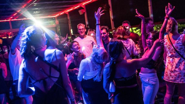 CANGGU, BALI, INDONESIA - DECEMBER 7: Tourists gesture as they dance on a dance floor at a bar on December 7, 2022 in Canggu, Bali, Indonesia. Indonesia's parliament voted to pass a law that bans extramarital sex on Tuesday, in a move that critics quoted in local media have said will severely impact the tourism industry. Regions like Bali rely heavily on an influx of foreign tourists to keep their economies afloat, and the new law has raised concerns just as international arrivals start to pick up again post-pandemic.  (Photo by Agung Parameswara/Getty Images)
