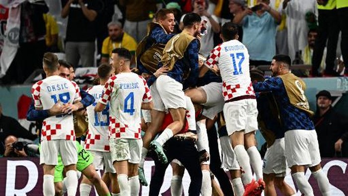Croatias forward #16 Bruno Petkovic celebrates with teammates after scoring his teams first goal during the Qatar 2022 World Cup quarter-final football match between Croatia and Brazil at Education City Stadium in Al-Rayyan, west of Doha, on December 9, 2022. (Photo by GABRIEL BOUYS / AFP)
