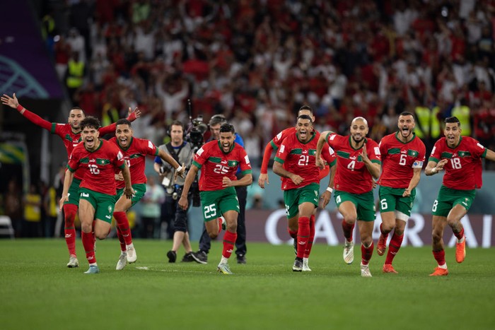 AR-RAYYAN, QATAR - DECEMBER 06: Morocco players run to winning penalty goalscorer Achraf Hakimi of Morocco and Morocco goalkeeper Yassine Bounou as they beat Spain on penalties during the FIFA World Cup Qatar 2022 Round of 16 match between Morocco (0) and Spain (0) (Morocco win 3-0 on penalties) at Education City Stadium on December 06, 2022 in Ar-Rayyan, Qatar. (Photo by Simon Bruty/Anychance/Getty Images)
