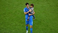 Penjaga gawang Maroko Yassine Bounou merayakan kemenangan atas Portugal dengan anaknya di dalam lapangan Al Thumama Stadium.