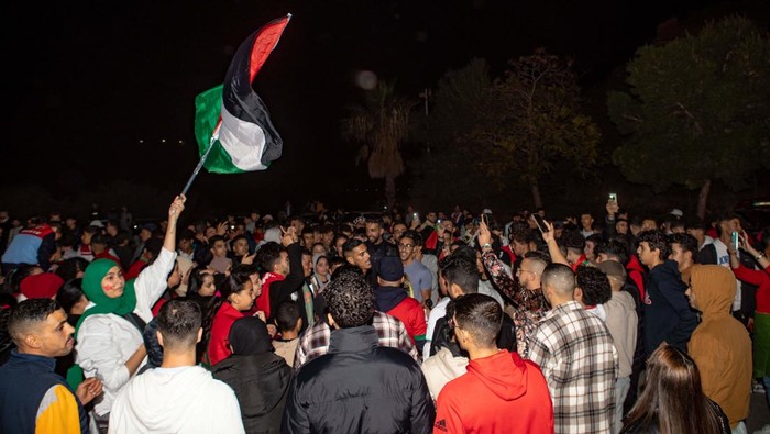 Bendera Palestina Berkibar di Tengah Pesta Pendukung Maroko GRANADA, SPAIN - DECEMBER 10: Supporters of Morocco national team celebrate in the streets of Granada the victory against Portugal in FIFA World Cup Qatar 2022 Quarter-Finals on December 10, 2022 in Granada, Spain. (Photo by Alex Camara/Anadolu Agency via Getty Images)