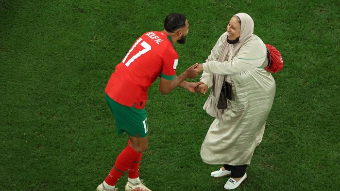 Menang Atas Portugal, Boufal Menari-nari dengan Ibunya DOHA, QATAR - DECEMBER 10: Sofiane Boufal of Morocco celebrates with a family member after the team's 1-0 victory in the FIFA World Cup Qatar 2022 quarter final match between Morocco and Portugal at Al Thumama Stadium on December 10, 2022 in Doha, Qatar. (Photo by Mike Hewitt - FIFA/FIFA via Getty Images)