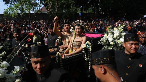 Pasangan pengantin baru Kaesang Pangarep dan Erina Gudono menjalani upacara kirab menggunakan kereta kencana di sepanjang Jalan Slamet Riyadi, Solo, Minggu (11/12/2022). (CNBC Indonesia/ Muhammad Sabki)