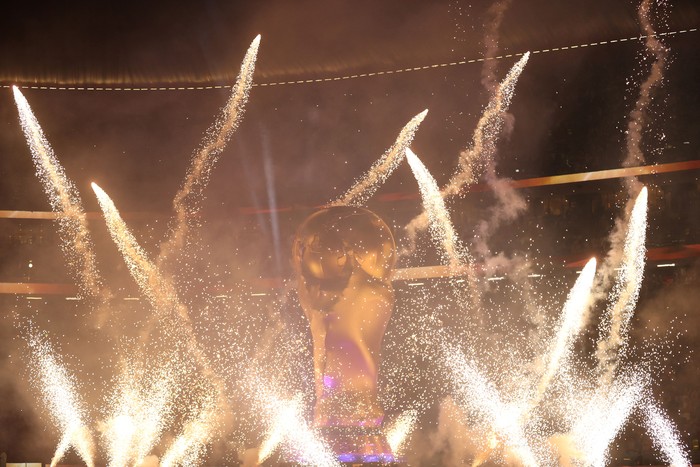Fireworks go off around a giant replica of the World Cup trophy before the start of the Qatar 2022 World Cup quarter-final football match between England and France at the Al-Bayt Stadium in Al Khor, north of Doha, on December 10, 2022. (Photo by ADRIAN DENNIS / AFP) (Photo by ADRIAN DENNIS/AFP via Getty Images)