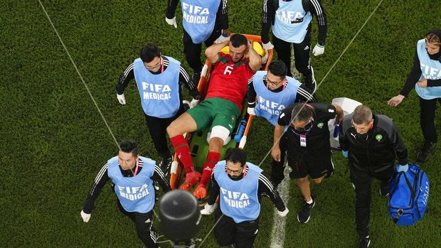 Morocco's Romain Saiss reacts as he is taken away from the pitch on a stretcher after picking up an injury during the World Cup quarterfinal soccer match between Morocco and Portugal, at Al Thumama Stadium in Doha, Qatar, Saturday, Dec. 10, 2022. (AP Photo/Thanassis Stavrakis)