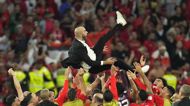 Smashot Edisi 11 Desember 2022 Morocco's head coach Walid Regragui is thrown in the air at the end of the World Cup round of 16 soccer match between Morocco and Spain, at the Education City Stadium in Al Rayyan, Qatar, Tuesday, Dec. 6, 2022. (AP Photo/Julio Cortez)