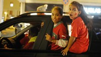 Dua anak perempuan yang duduk di jendela mobil, ikut memeriahkan kemenangan tim sepakbola Maroko. (Laura Lezza/Getty Images)