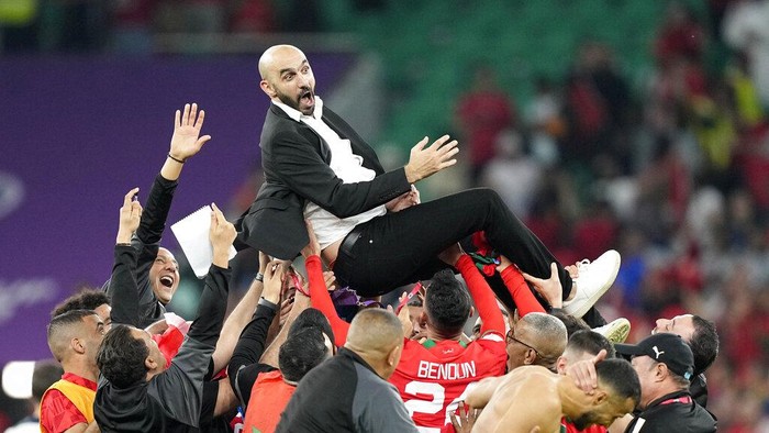 Moroccos head coach Walid Regragui is thrown in the air by players after the World Cup quarterfinal soccer match between Morocco and Portugal, at Al Thumama Stadium in Doha, Qatar, Saturday, Dec. 10, 2022. (AP Photo/Martin Meissner)
