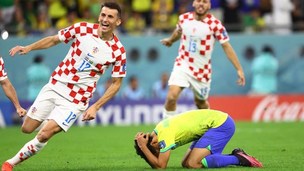 Soccer Football - FIFA World Cup Qatar 2022 - Quarter Final - Croatia v Brazil - Education City Stadium, Doha, Qatar - December 9, 2022 Croatia's Ante Budimir celebrates winning the penalty shootout after Brazil's Marquinhos looks dejected after he misses his penalty REUTERS/Hannah Mckay