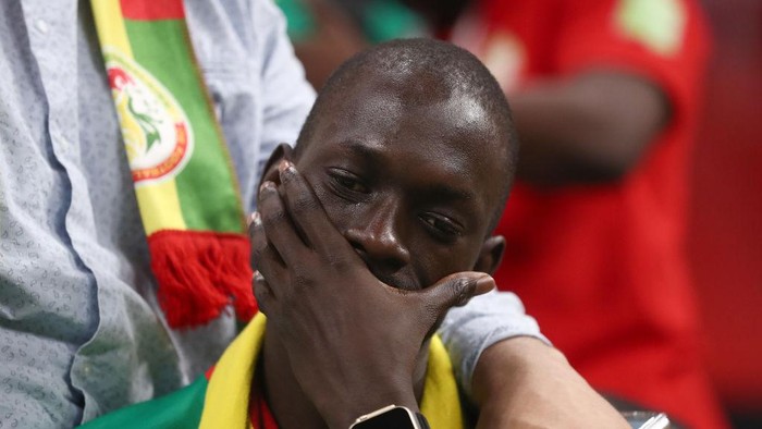 AL KHOR, QATAR - DECEMBER 04: A dejected fan of Senegal cries at full time after his team is knocked out of the FIFA World Cup during the FIFA World Cup Qatar 2022 Round of 16 match between England and Senegal at Al Bayt Stadium on December 4, 2022 in Al Khor, Qatar. (Photo by James Williamson - AMA/Getty Images)