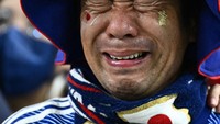 Di babak adu penalti babak 16 besar pula suporter Jepang ini larut dalam duka, usai Samurai Biru dikalahkan Kroasia. Foto: AFP via Getty Images/JEWEL SAMAD