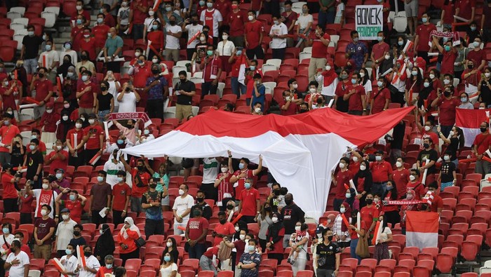 Indonesia fans cheer on their team before the first leg of the AFF Suzuki Cup 2020 football final match against Thailand at the National Stadium in Singapore on December 29, 2021. (Photo by Roslan RAHMAN / AFP) (Photo by ROSLAN RAHMAN/AFP via Getty Images)