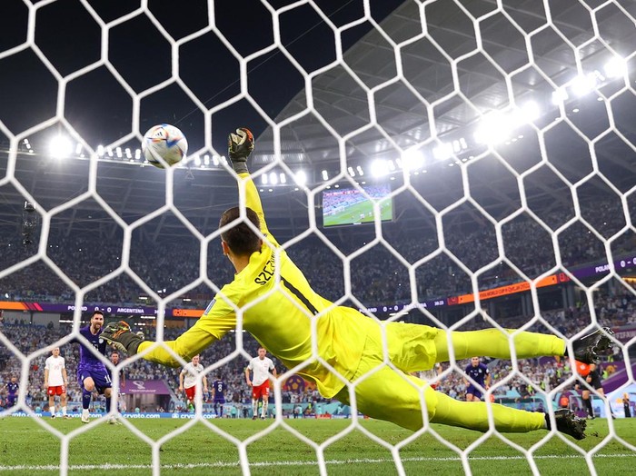 DOHA, QATAR - NOVEMBER 30: (EDITORS NOTE: In this photo taken from a remote camera from behind the goal) Lionel Messi of Argentina takes a penalty saved by Wojciech Szczesny of Poland during the FIFA World Cup Qatar 2022 Group C match between Poland and Argentina at Stadium 974 on November 30, 2022 in Doha, Qatar. (Photo by Richard Heathcote/Getty Images)