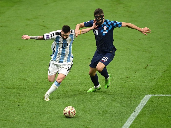 LUSAIL CITY, QATAR - DECEMBER 13: Lionel Messi of Argentina and Josko Gvardiol of Croatia compete for the ball during the FIFA World Cup Qatar 2022 semi final match between Argentina and Croatia at Lusail Stadium on December 13, 2022 in Lusail City, Qatar. (Photo by David Ramos - FIFA/FIFA via Getty Images)