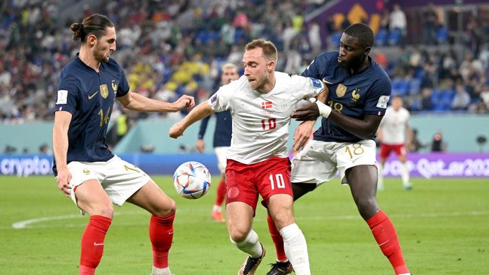 DOHA, QATAR - NOVEMBER 26: Christian Eriksen of Denmark controls the ball under pressure of Adrien Rabiot and Dayot Upamecano of France  during the FIFA World Cup Qatar 2022 Group D match between France and Denmark at Stadium 974 on November 26, 2022 in Doha, Qatar. (Photo by Clive Mason/Getty Images)