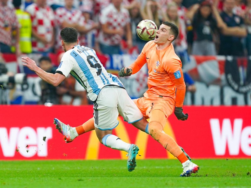 LUSAIL CITY, QATAR - DECEMBER 13: Dominik Livakovic (R) goalkeeper of Croatia fights for the ball with Julian Alvarez (L) of Argentina during the FIFA World Cup Qatar 2022 semi final match between Argentina and Croatia at Lusail Stadium on December 13, 2022 in Lusail City, Qatar. (Photo by Khalil Bashar/Jam Media/Getty Images)