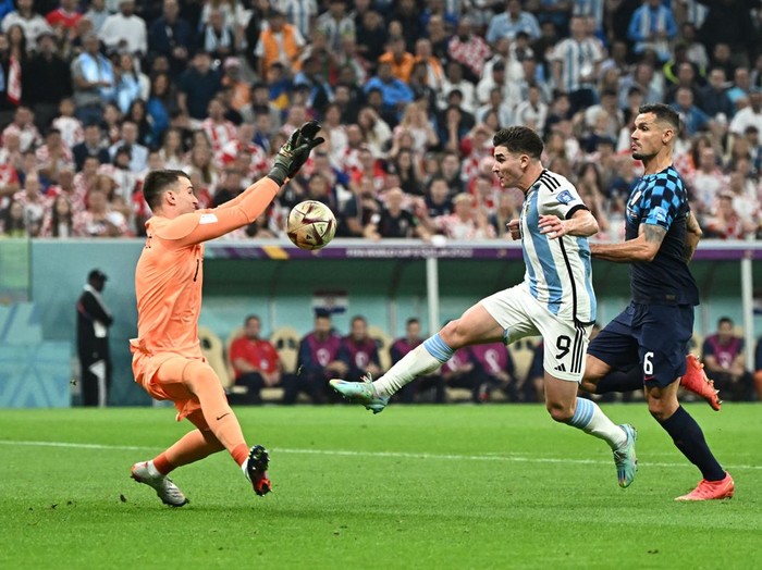 Argentina's forward #09 Julian Alvarez tries to score before being fouled by Croatia's goalkeeper #01 Dominik Livakovic (L) in the penalty box as Croatia's defender #06 Dejan Lovren looks on during the Qatar 2022 World Cup football semi-final match between Argentina and Croatia at Lusail Stadium in Lusail, north of Doha on December 13, 2022. (Photo by Jewel SAMAD / AFP) (Photo by JEWEL SAMAD/AFP via Getty Images)