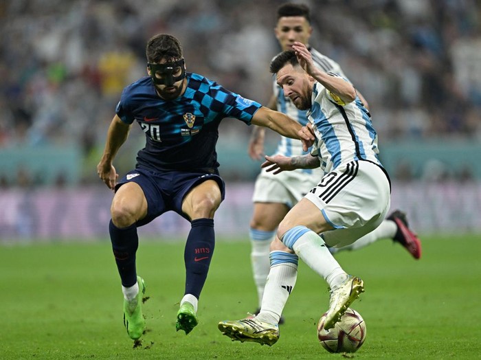 Croatia's defender #20 Josko Gvardiol and Argentina's forward #10 Lionel Messi fight for the ball during the Qatar 2022 World Cup football semi-final match between Argentina and Croatia at Lusail Stadium in Lusail, north of Doha on December 13, 2022. (Photo by JUAN MABROMATA / AFP) (Photo by JUAN MABROMATA/AFP via Getty Images)