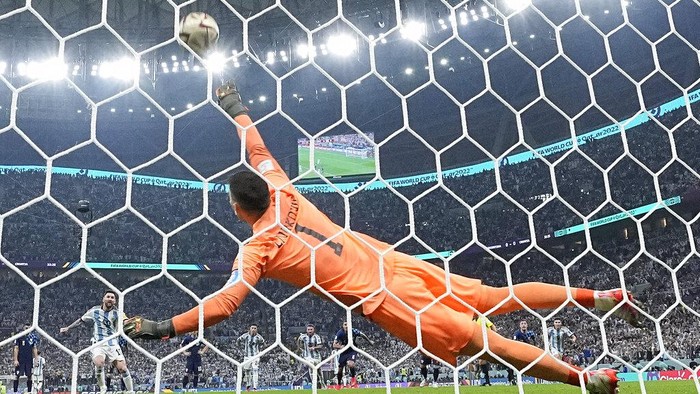 Argentinas Lionel Messi scores the opening goal from the penalty spot past Croatias goalkeeper Dominik Livakovic during the World Cup semifinal soccer match between Argentina and Croatia at the Lusail Stadium in Lusail, Qatar, Tuesday, Dec. 13, 2022. (AP Photo/Martin Meissner)