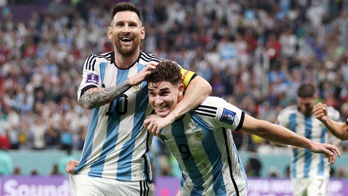 Julian Alvarez merayakan dengan rekan setimnya Lionel Messi setelah mencetak gol kedua tim mereka selama pertandingan semifinal Piala Dunia FIFA Qatar 2022 antara Argentina dan Kroasia di Stadion Lusail, Qatar, Selasa (13/12/2022). (Richard Heathcote/Getty Images)