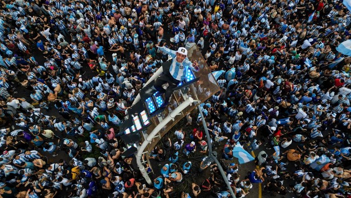 Waduh, Fans Argentina Terlalu Gembira Sampai Naik Tiang Lampu BUENOS AIRES, ARGENTINA - DECEMBER 13: Fans of Argentina celebrate at the Obelisk after their team's victory in the semi-final match of FIFA World Cup Qatar 2022 between Argentina and Croatia on December 13, 2022 in Buenos Aires, Argentina. (Photo by Tomas Cuesta/Getty Images)