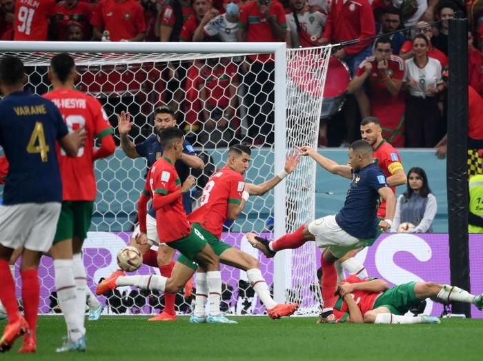 France's forward #10 Kylian Mbappe (R) shoots ahead of his team's first goal during the Qatar 2022 World Cup semi-final football match between France and Morocco at the Al-Bayt Stadium in Al Khor, north of Doha on December 14, 2022. (Photo by FRANCK FIFE / AFP) (Photo by FRANCK FIFE/AFP via Getty Images)